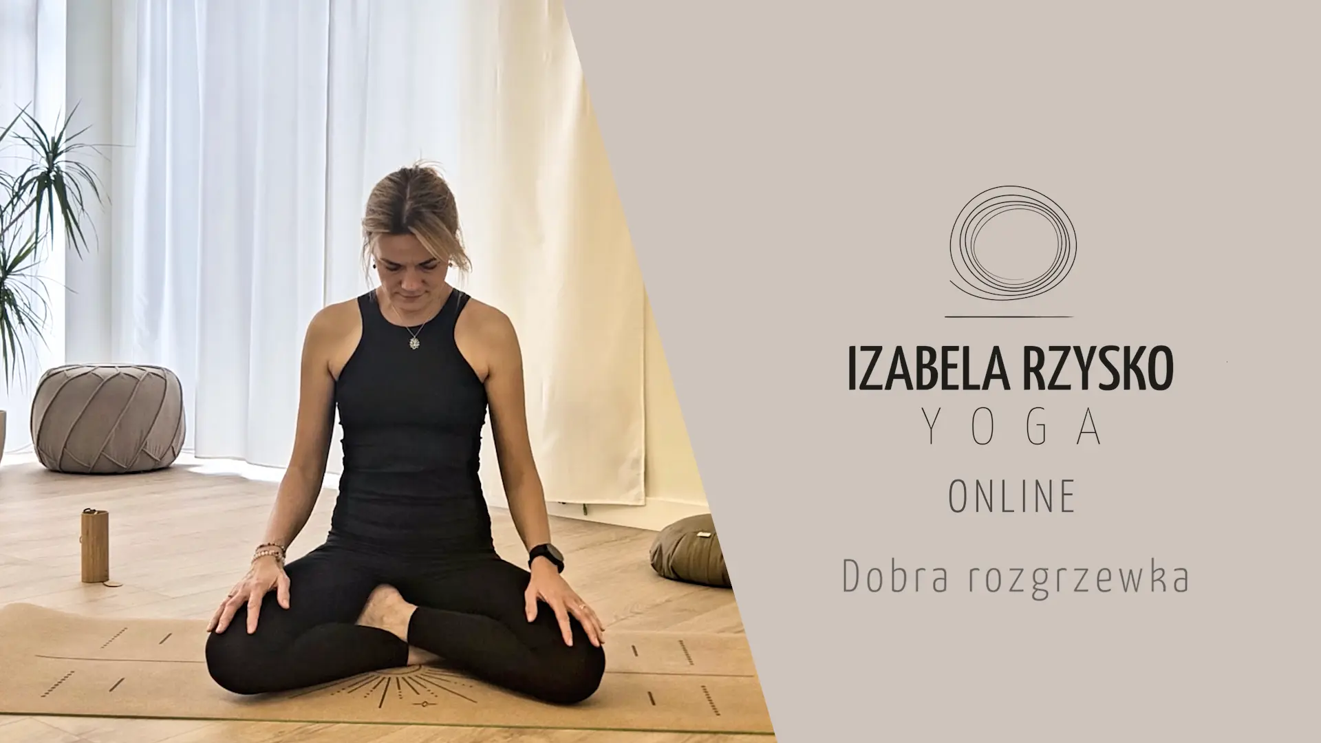 Kobieta siedzi ze skrzyżowanymi nogami na macie do jogi, patrząc w dół, w jasnym, minimalistycznym pokoju. Tekst po prawej stronie brzmi: Izabela Rzysko Yoga Online, Dobra rozgrzewka, z prostym okrągłym logo powyżej.