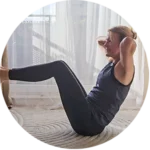 Kobieta w sportowym ubraniu wykonuje przysiady na dywanie w jasnym pokoju z zasłonami i naturalnym światłem.