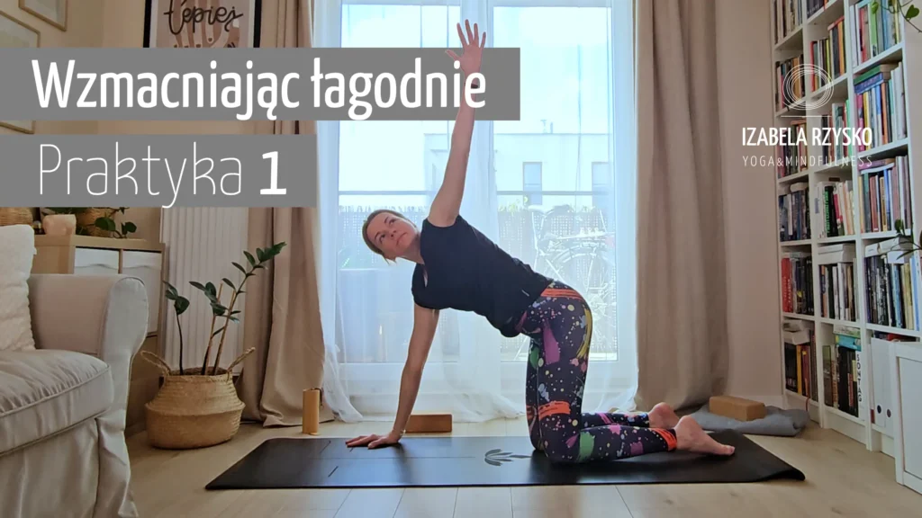 Kobieta ćwiczy jogę w pomieszczeniu na macie, wyciągając jedną rękę w górę podczas klęczenia. Tekst w języku polskim brzmi Wzmacniając łagodnie Praktykę 1. Pokój ma duże okna, rośliny i rekwizyty do jogi.