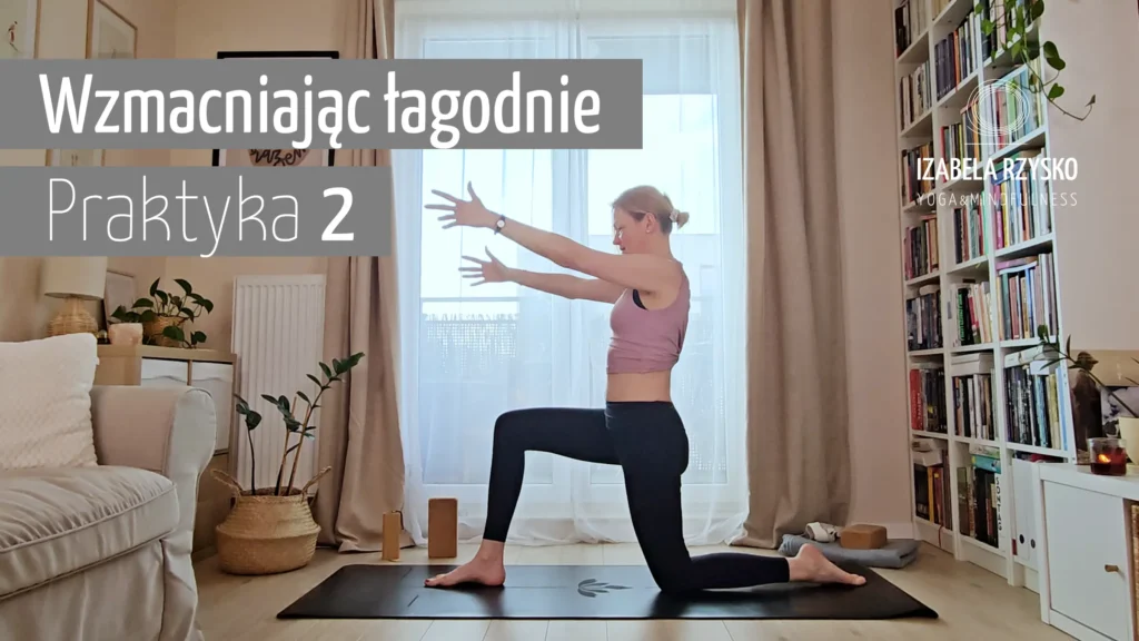 Kobieta ćwiczy jogę w salonie, klęcząc na macie z rękami wyciągniętymi do przodu. Tekst w języku polskim brzmi Wzmacniając łagodną Praktykę 2. W przestrzeni znajdują się rośliny domowe, zasłony i półki z książkami.